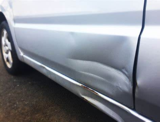 Example of a soccer-ball size dent on a silver car